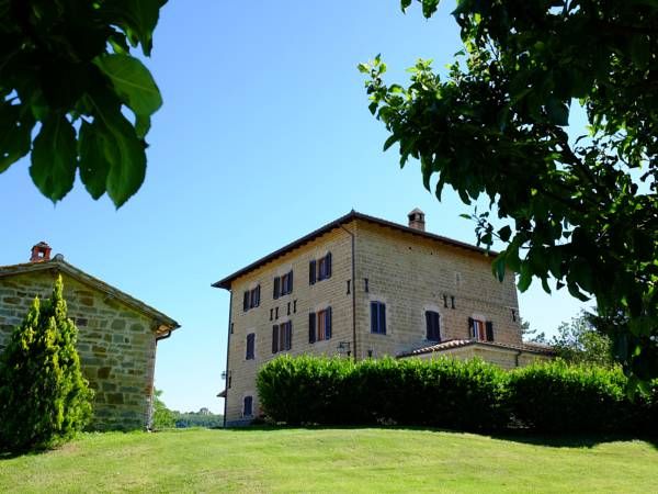 Spaziosa villa in pietra circondata da un ampio giardino, perfetta per momenti di relax e svago all'aria aperta.