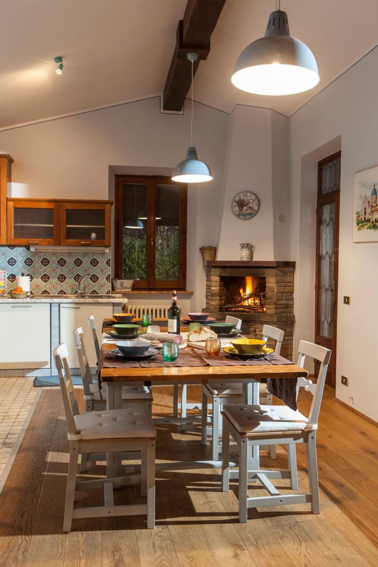 Sala da pranzo con tavolo apparecchiato e camino acceso, ideale per pasti in compagnia.