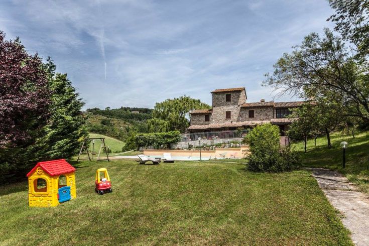 Un casale comodo circondato da un'area verde, dotato di piscina e zone adatte per il gioco all'aperto.