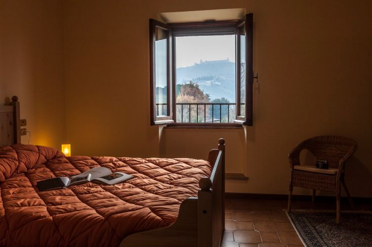 Camera accogliente con panorama sulla campagna circostante, adatta per momenti di relax e lettura.