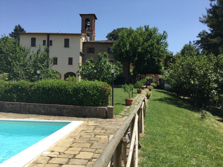 Tipico casale umbro circondato dalla vegetazione, con piscina e giardino, perfetto per una vacanza rilassante.
