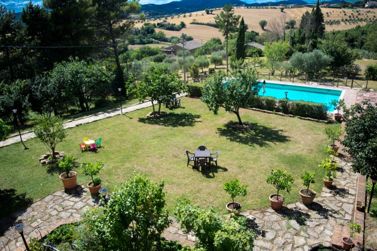 Un giardino spazioso con una piscina, progettato per godere di momenti di relax all'aria aperta.