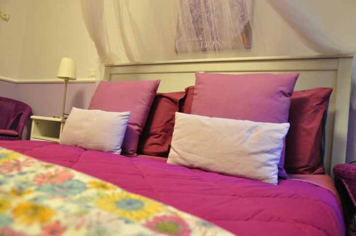 Comfortable and simple bedroom with pink bedding and subtle decorations.