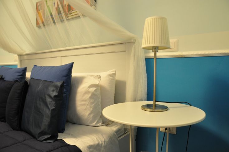 A simple room with comfortable beds and a lamp, perfect for a peaceful stay.