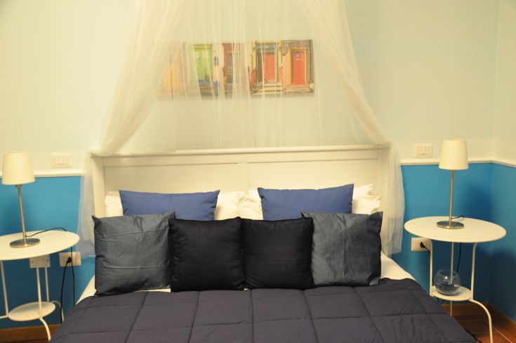 Simple and cozy room with blue linens and modern decorations.