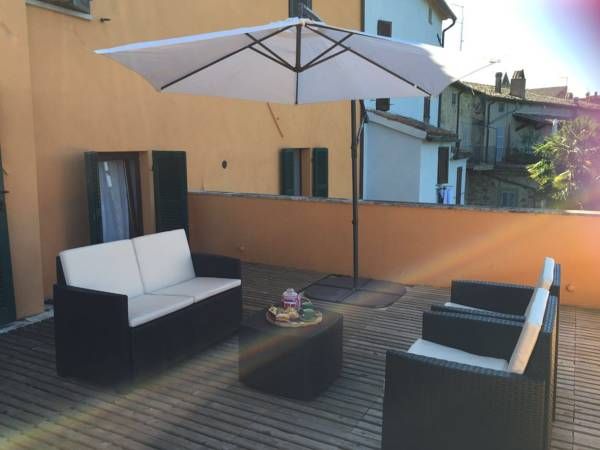 Well-maintained outdoor terrace featuring cozy sofas and an umbrella for relaxing moments in the sun.