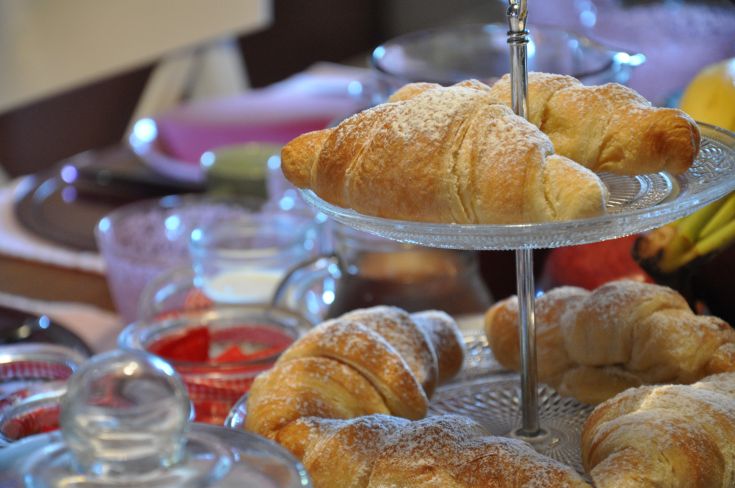 A variety of sugared croissants placed on a table in a simple and cozy setting.