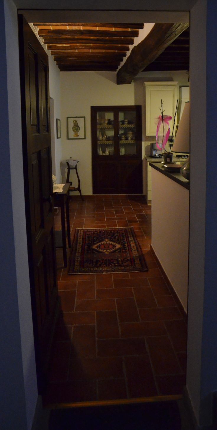 Cozy corridor entrance featuring exposed beams and terracotta flooring, creating a warm and inviting atmosphere.