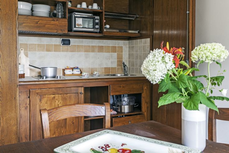 Cucina in legno con decorazioni floreali, uno spazio sereno e autentico, adatto per occasioni piacevoli.