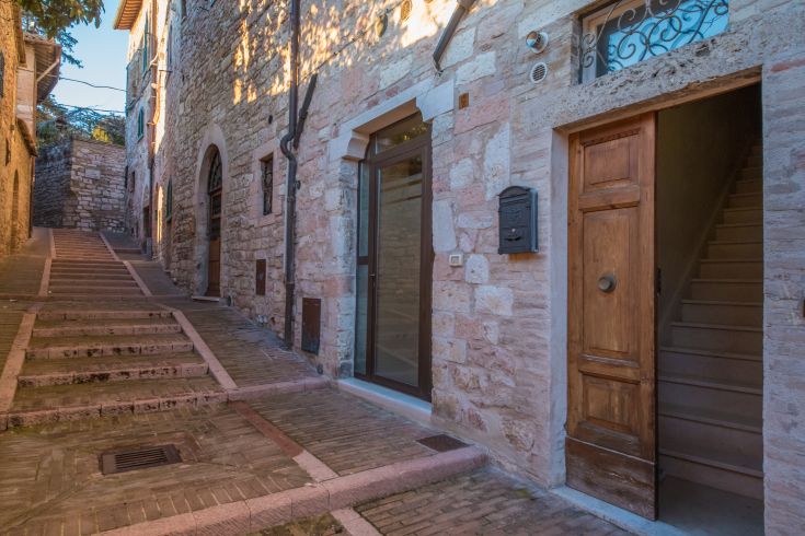 A quiet street with stone buildings, a characteristic corner of the Assisi area.