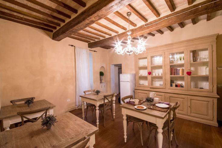 A cozy dining area with wooden tables and pleasant central lighting.