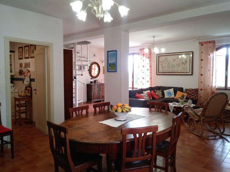 A simple living room featuring a large table, rustic decor, and a surrounding green landscape. Perfect for families.