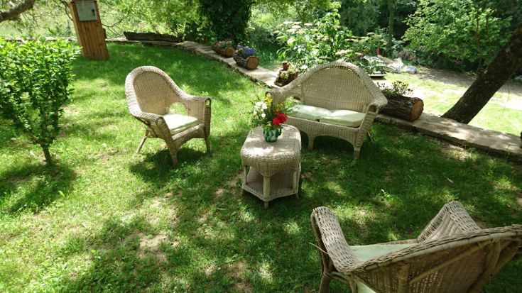 Une zone extérieure avec des fauteuils confortables en rotin, parfaite pour des moments de détente entourés de verdure.
