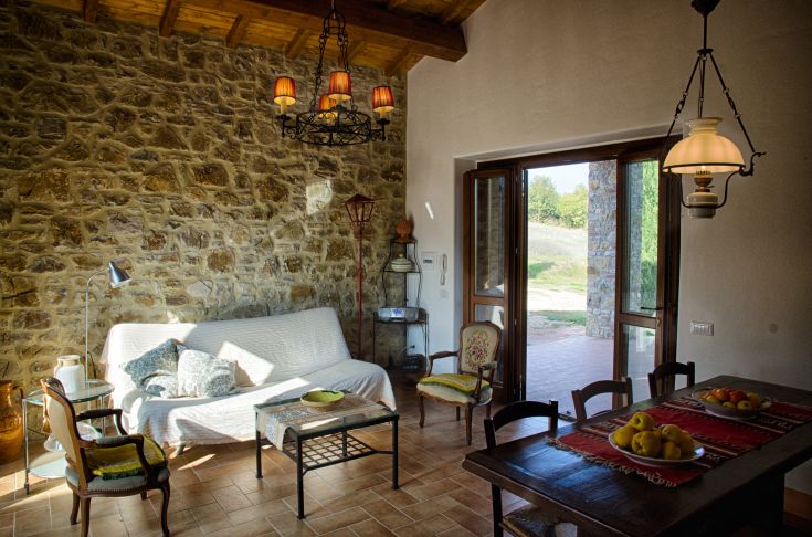 Ein gemütliches Wohnzimmer mit Steinwänden und komfortablen Möbeln, perfekt zum Entspannen.