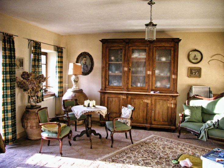 Ein einfacher rustikaler Wohnraum mit traditioneller Möbeln und sanfter natürlicher Beleuchtung.