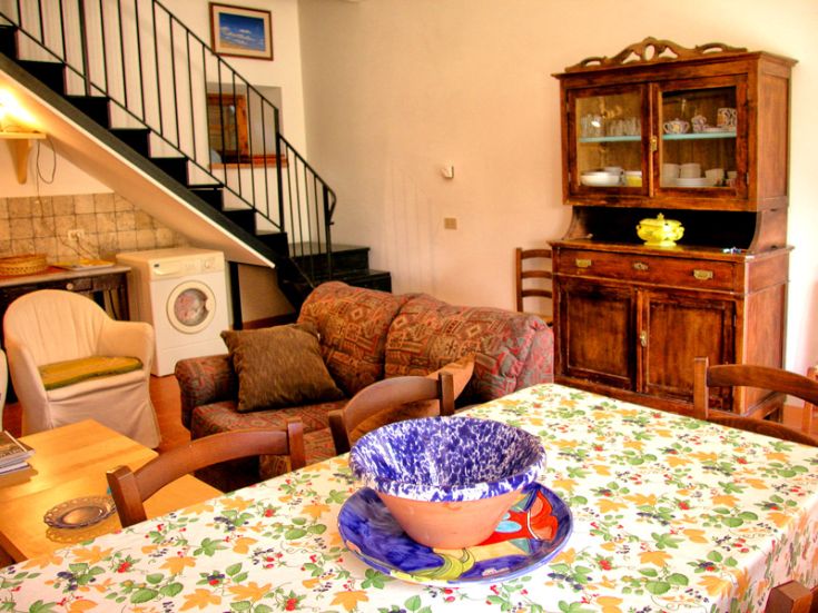 Einfaches Wohnzimmer mit Küche und Essbereich, perfekt für Familien und kleine Gruppen von Freunden.