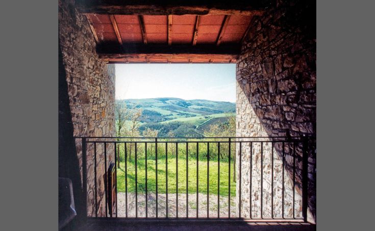 Szene aus einem renovierten Palast, umgeben von grüner Natur, mit Blick auf eine ruhige Landschaft.