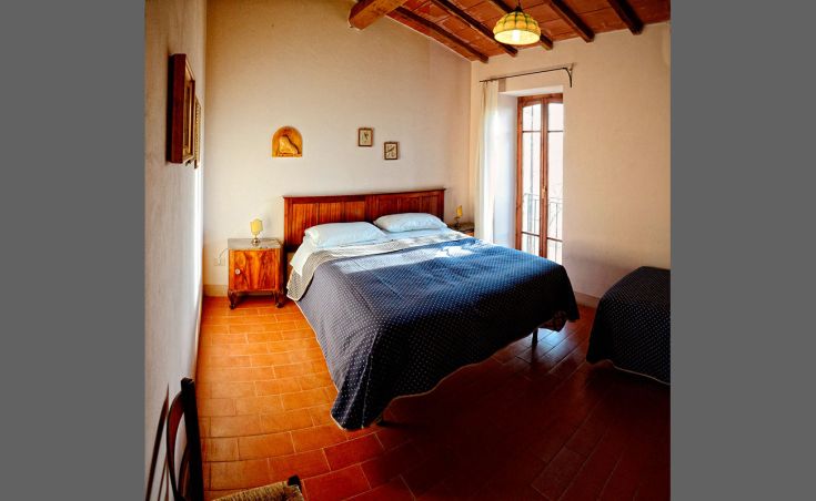 Gemütliches Zimmer in einem Gebäude mit traditionellen Elementen und grundlegenden Annehmlichkeiten, ideal für Familien und Gruppen.