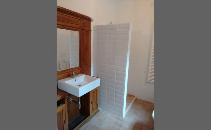 Ein gemütliches Badezimmer mit modernem Waschbecken und separater Dusche, in einer komfortablen Wohnung.