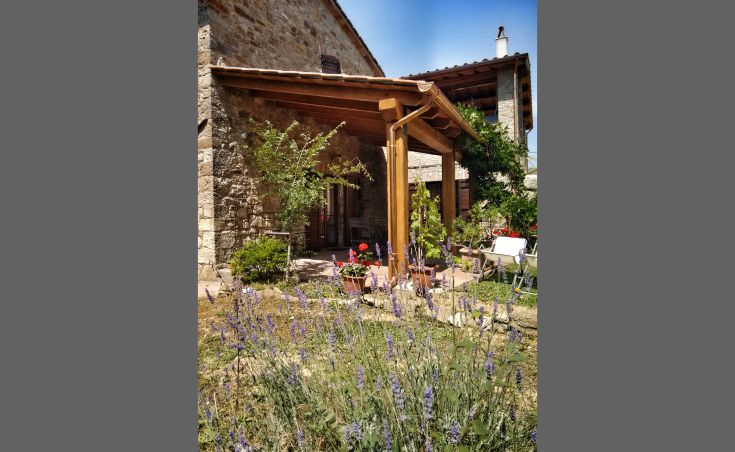 Ein steinernes Gebäude, umgeben von einem bunten Garten, ideal für Entspannungsmomente.