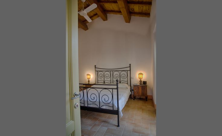 Gemütliches Wohnzimmer mit einem Eisenbett und warmem, entspannendem Licht.