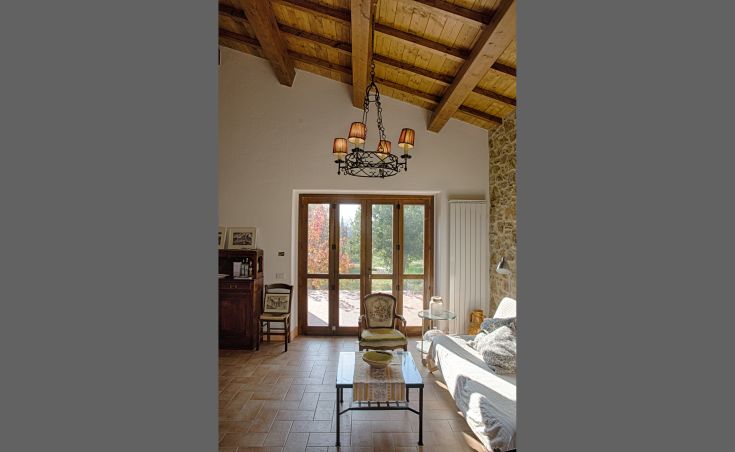 Innenansicht einer Wohnung in einem renovierten Gebäude, mit minimalistischer Einrichtung und Blick auf den Garten.