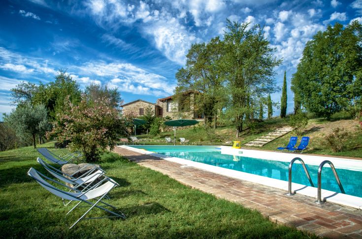 Ein ruhiger Bereich eines Gebäudes mit einem Pool, umgeben von grüner Natur, perfekt für eine entspannende Auszeit.