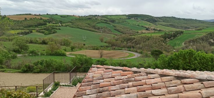 Szene von grünen Hügeln mit einem Steingebäude, das von der Natur umgeben ist. Ein angenehmes Freizeiterlebnis.