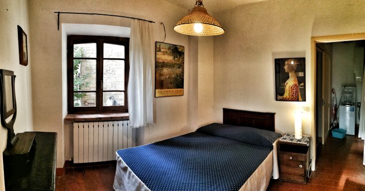 Entspannende Wohnung mit Doppelbett und Blick auf den Garten, ideal für Entspannungsmomente.
