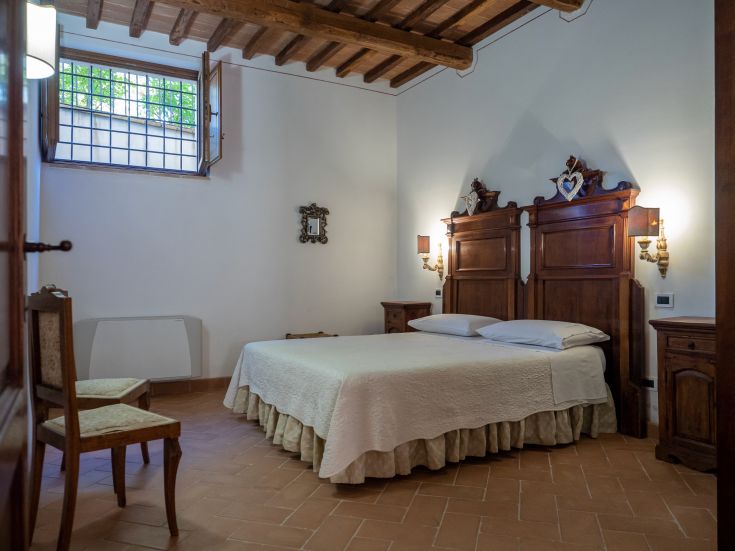 Camera semplice con arredi in legno chiaro e elementi dal design tradizionale, perfetta per un soggiorno tranquillo.