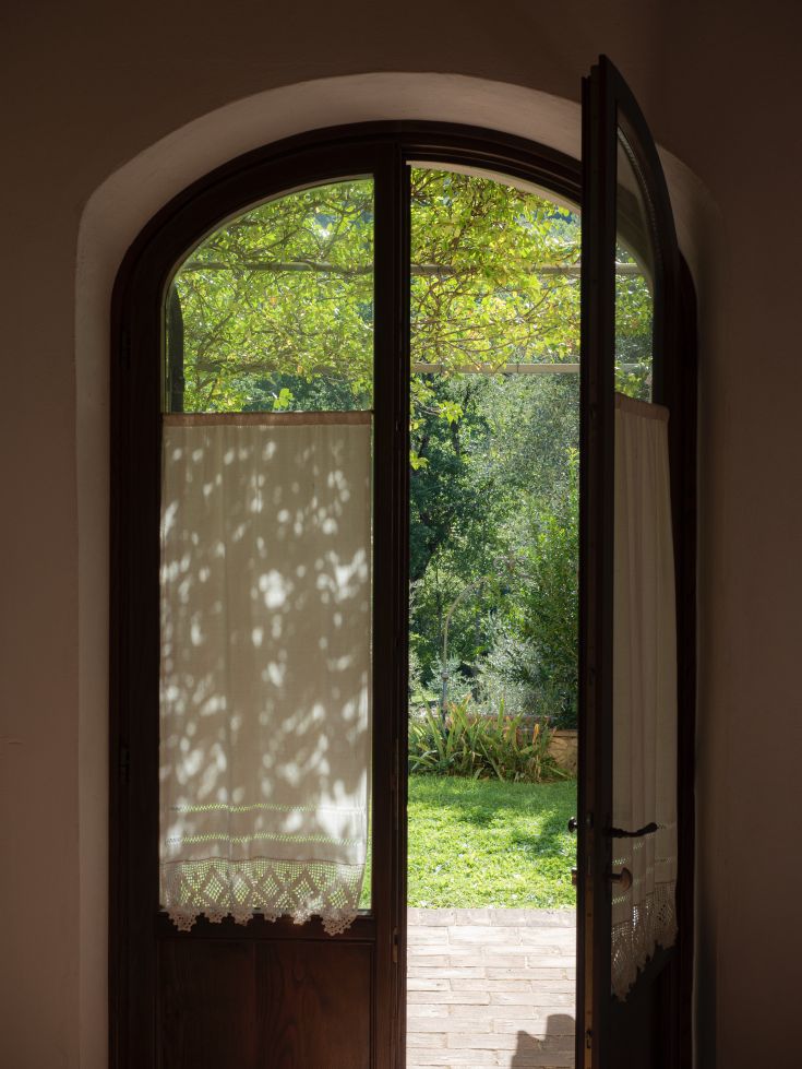 Una porta che si affaccia su un giardino ben curato, illuminato dalla luce naturale e dall'ambiente sereno.