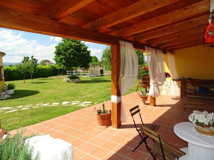 Entrance of a palace with well-maintained outdoor spaces, featuring green areas and simple furnishings.