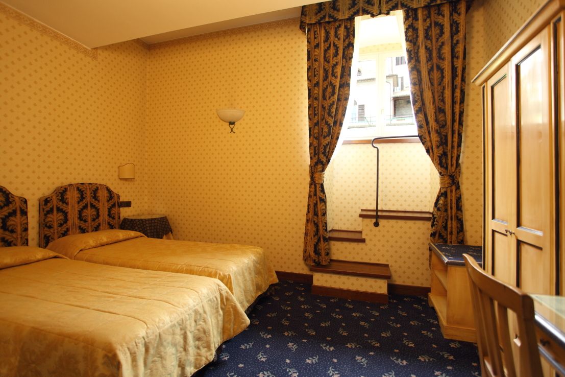Chambre simple avec des lits simples et un mobilier traditionnel.