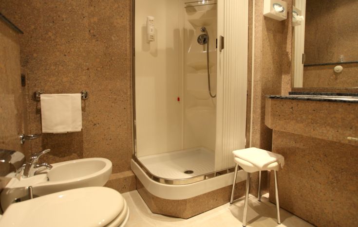 A simple bathroom with a shower, sink, and toilet. A modern and functional space.