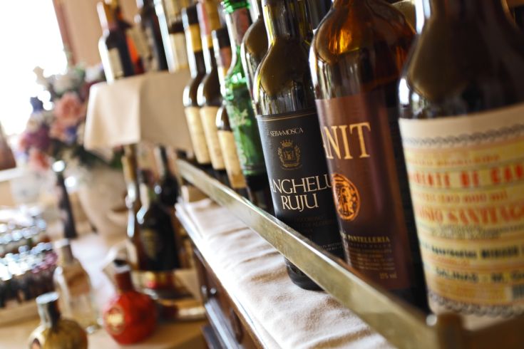 Wines arranged on a shelf, against a backdrop of flowers and soft lighting.
