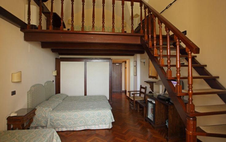 Simple room with a loft and wooden elements, perfect for a peaceful stay.