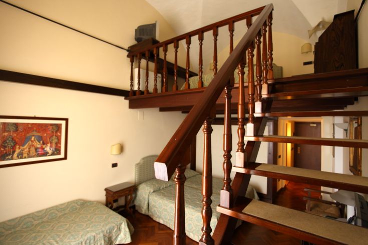 A cozy room with a loft and wooden furniture. A welcoming space for a peaceful stay.