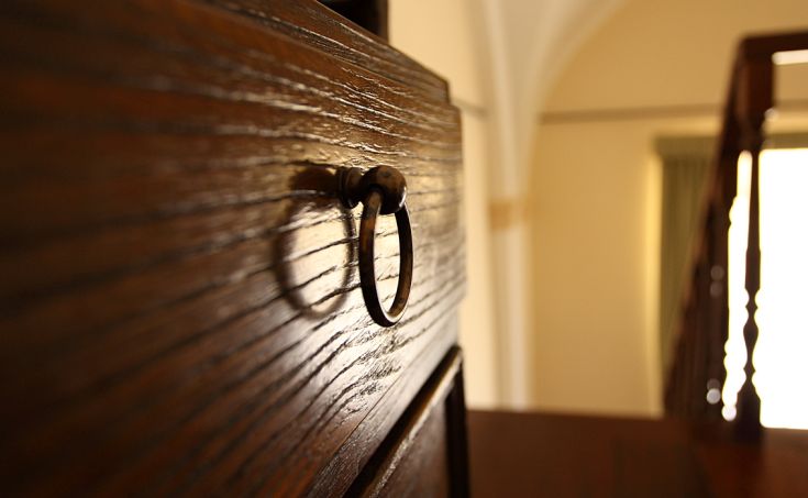 Close-up of a wooden drawer with a metal handle.
