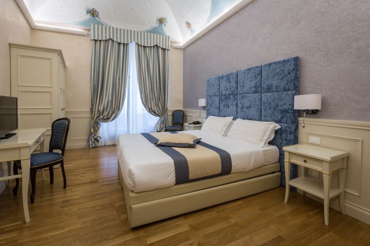 Camera con arredi semplici e moderni, dotata di una grande finestra che offre luce naturale.