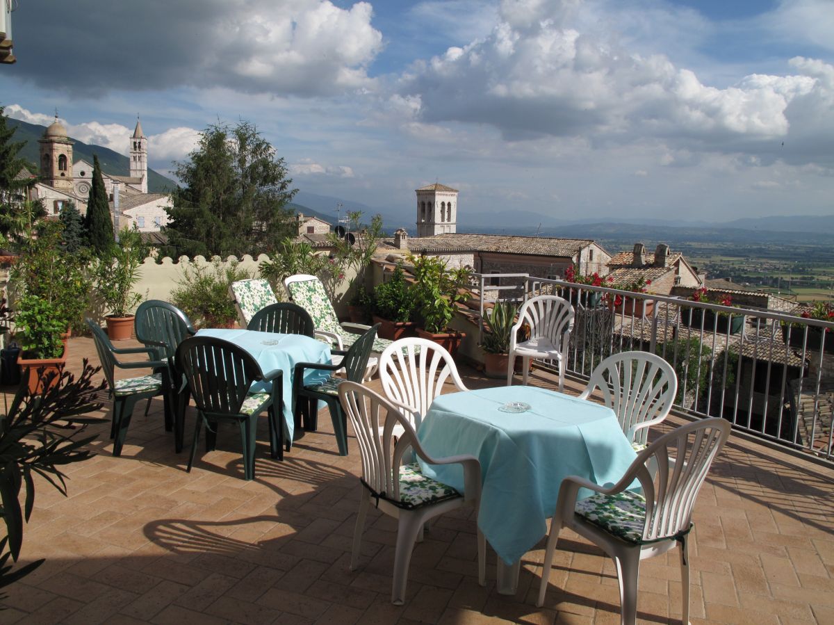 Terrasse lumineuse avec une vue imprenable, avec des tables et des chaises disposées pour les invités.