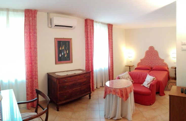 Ein einfach gestaltetes Hotelzimmer mit klassischen Elementen und warmen Farben, ideal zum Entspannen.