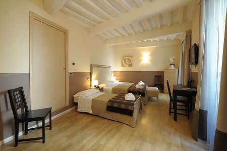 Comfortable hotel room with two single beds, simple decor, and a view of the surrounding area.