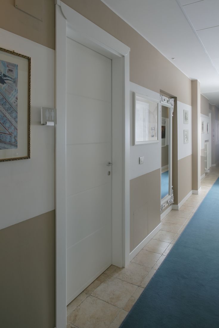 Un corridoio di un hotel, caratterizzato da elementi moderni e un'atmosfera accogliente, ideale per un soggiorno tranquillo.