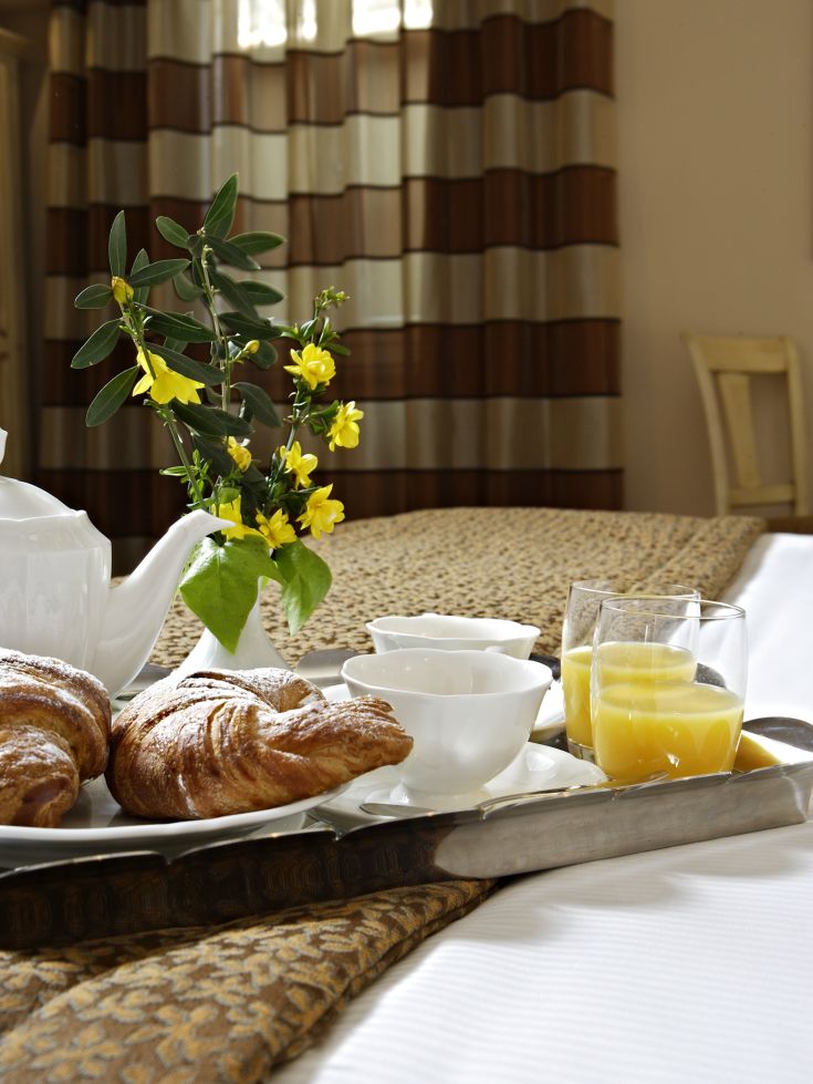 Colazione in camera con cornetti e succhi in un ambiente rilassato.