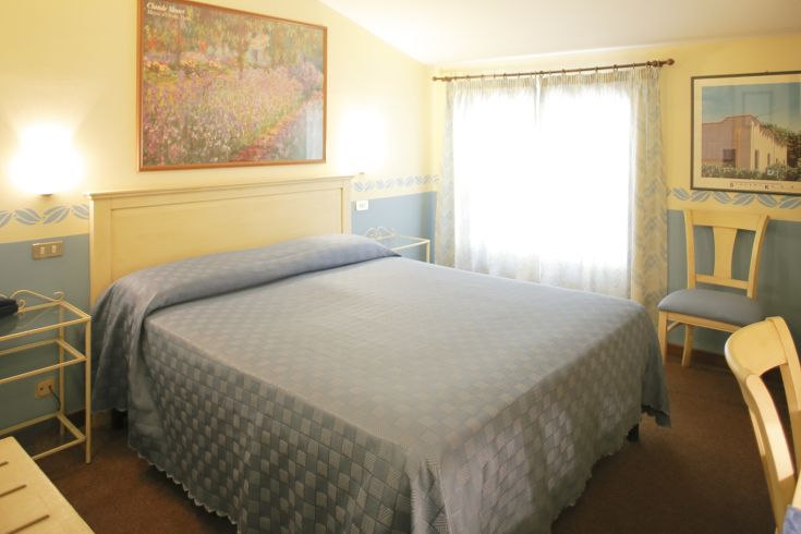 Camera accogliente con letti comodi e decorazioni semplici. Ideale per un soggiorno tranquillo.