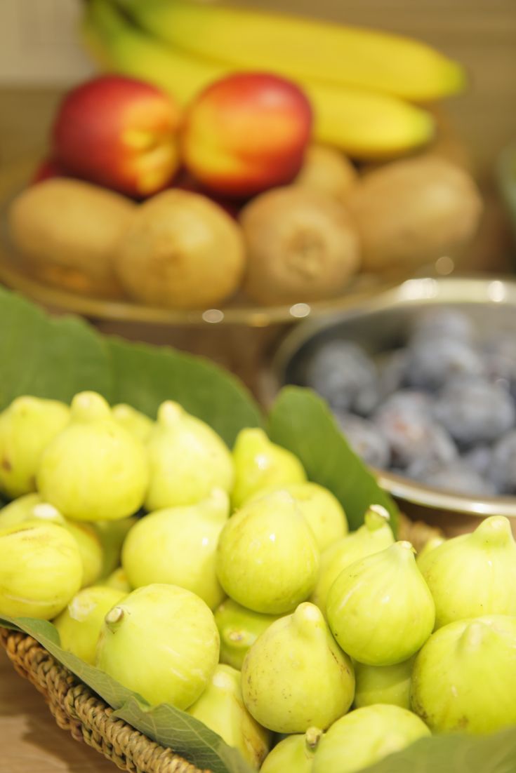 Un assortimento di frutta fresca come fichi, mele e banane disposto con semplicità su un tavolo.