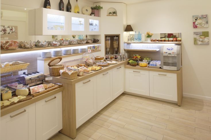 Un'area di una sala colazione con una selezione di dolci, formaggi e frutta.