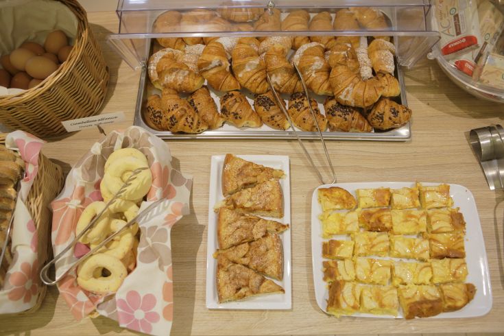 Un assortimento di cibi per colazione, con cornetti, dolci e uova fresche.