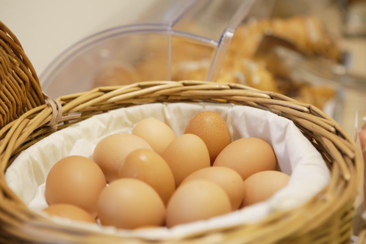 Una cesta di uova fresche, pronte per la colazione, che rappresentano un momento conviviale e genuino.