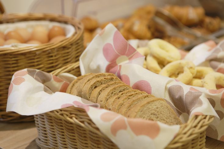 Buffet per la colazione con pane fresco, dolci e uova in un ambiente confortevole.